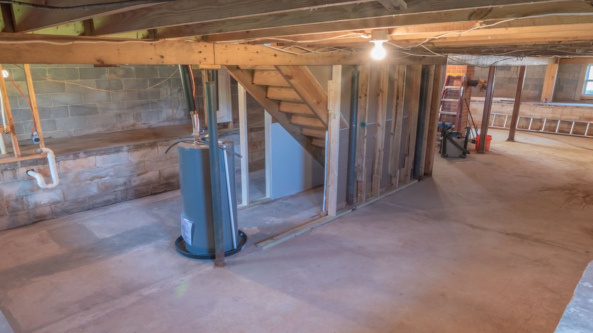 Licensed stock photograph: a water heater standing in a drip pan in an unfinished basement.